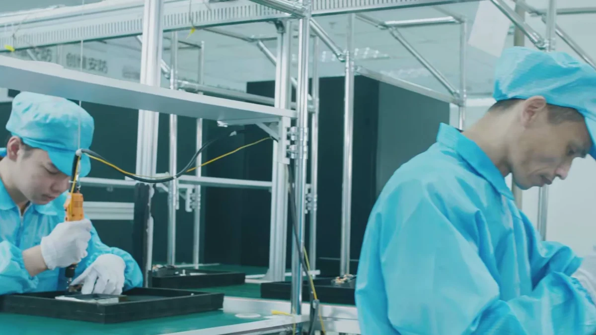 两名工人在工业装配线上使用电动工具完成工序