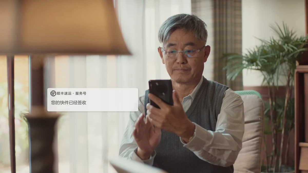 室内人物查看手机且画面左侧出现服务通知界面的广告视频画面