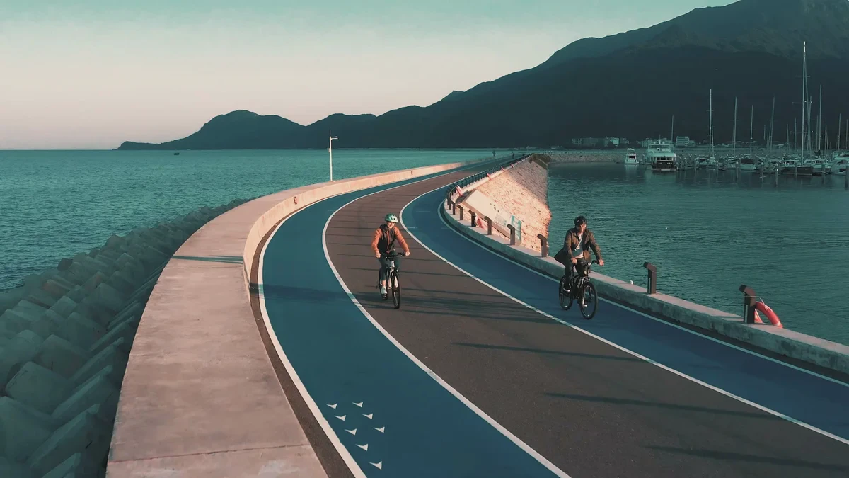 两名骑行者沿海堤道路骑行