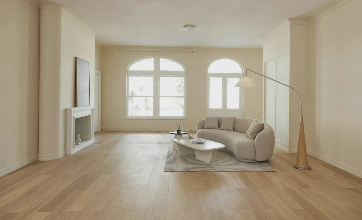 Bright living room with arched windows, pale timber floor and a cream sofa