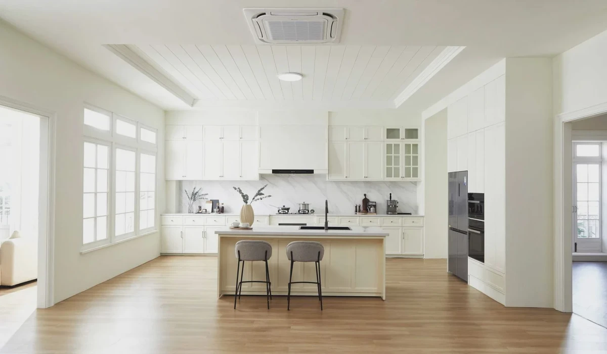 Bright family kitchen with white cabinetry, a central island and broad windows