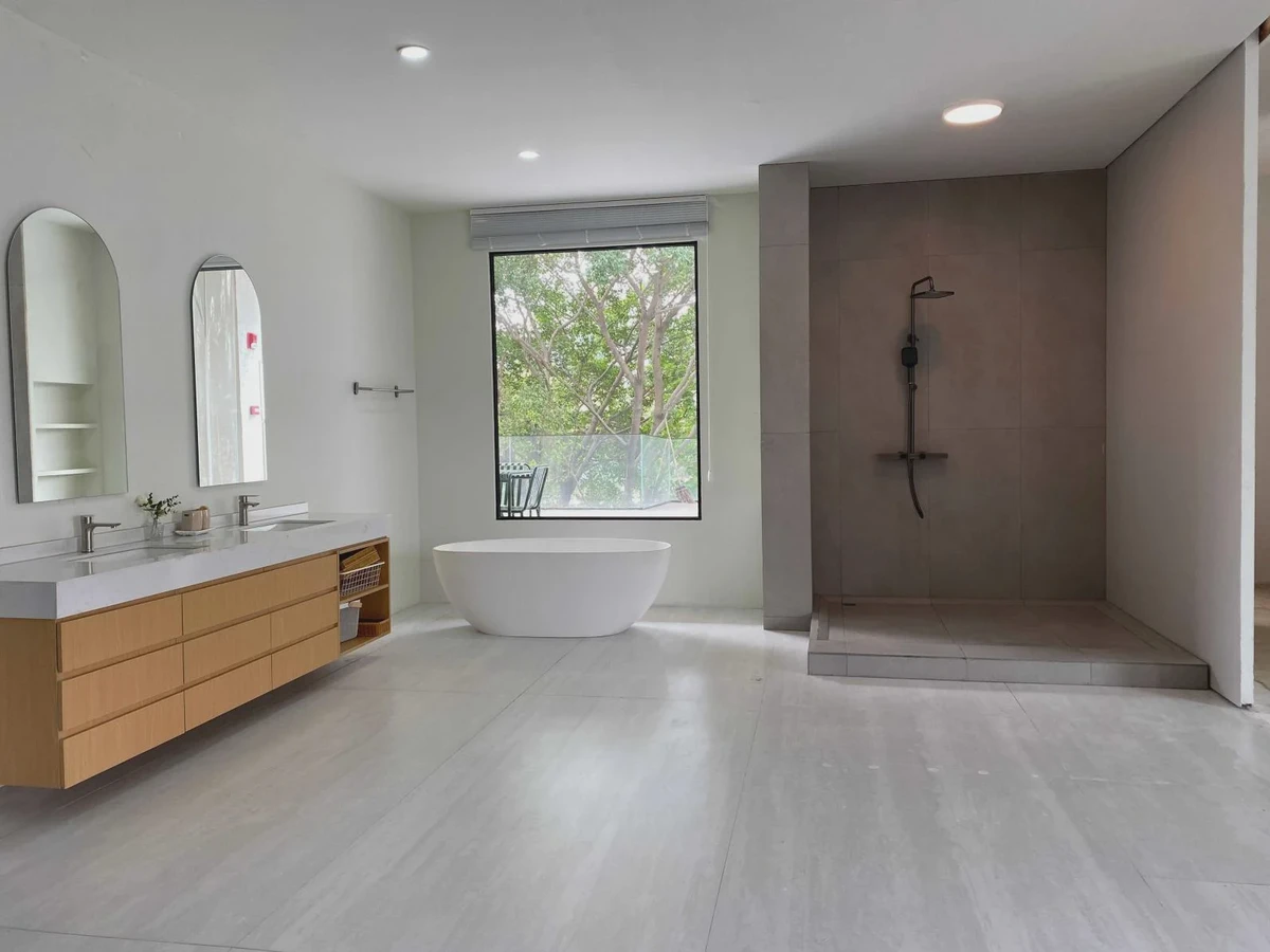 Daylit bathroom with twin basins, a bathtub and separate shower