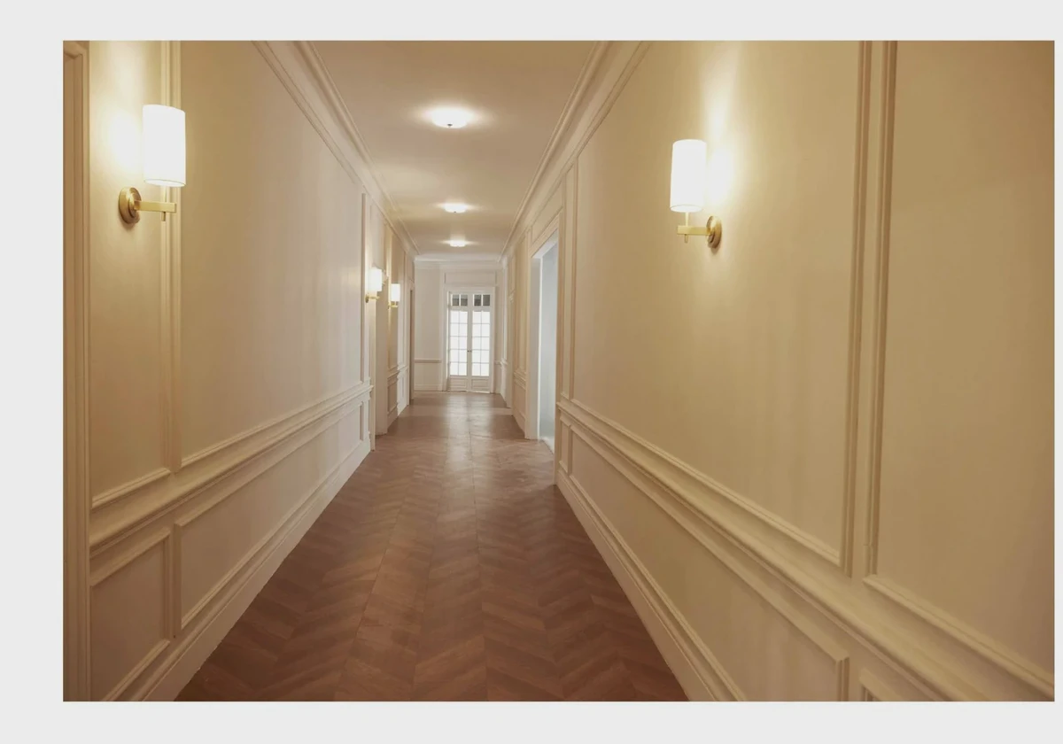 Classic interior corridor with wall mouldings, sconces and timber flooring