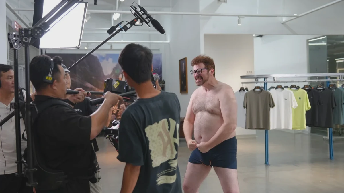 Behind the scenes of the undun brand film: performer beside a clothing display with camera crew